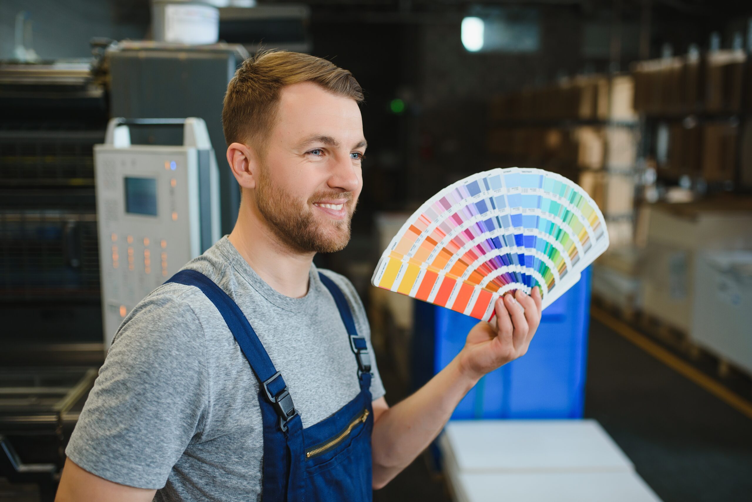 Funny portrait of typographer standing with color swatches at the printing manufacturing Reliaco Painting Fishers, IN